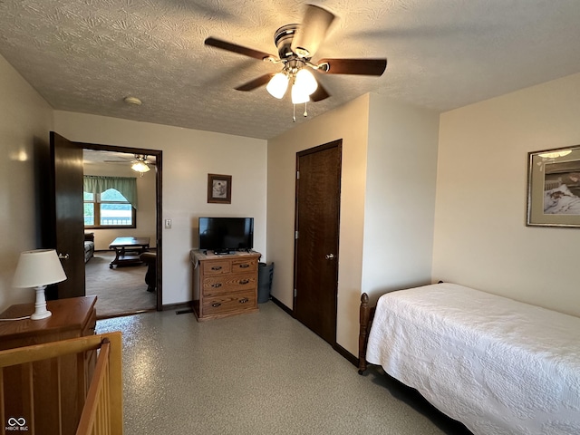 bedroom with baseboards, a ceiling fan, and a textured ceiling