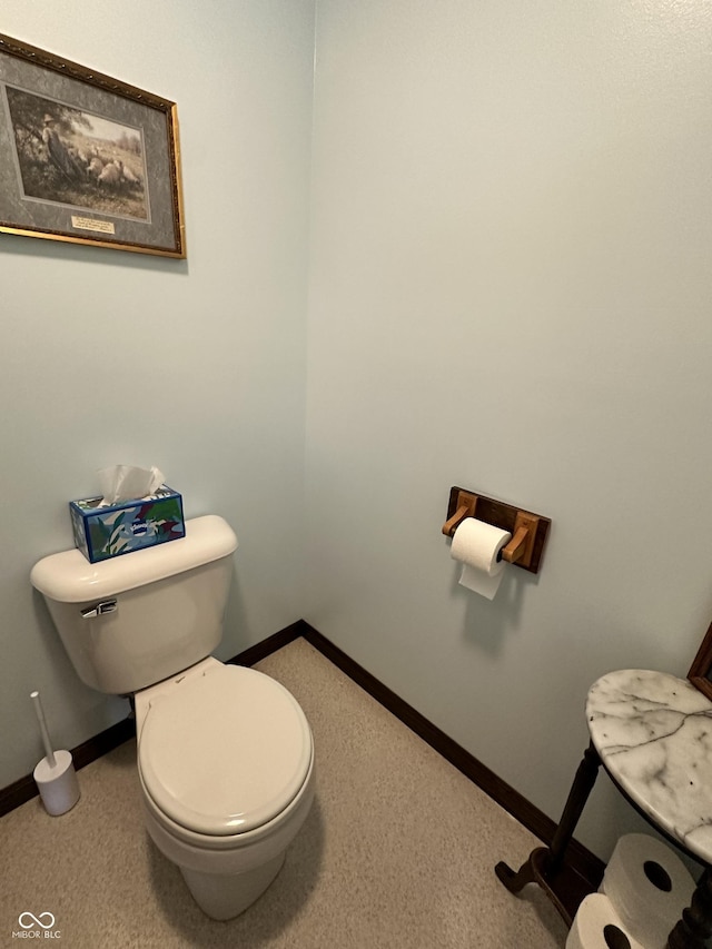 bathroom featuring baseboards and toilet