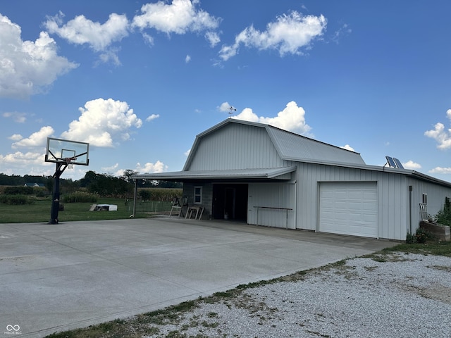 exterior space with a garage, a gambrel roof, and concrete driveway