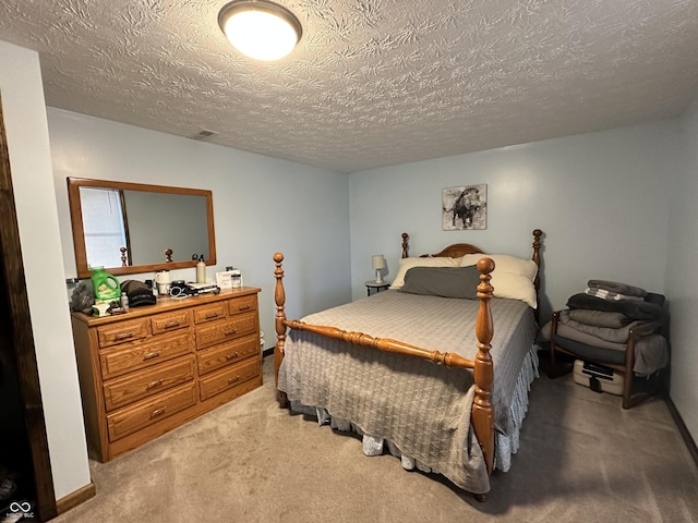 bedroom with a textured ceiling, visible vents, baseboards, and light carpet