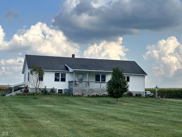 view of front facade featuring a chimney, a front yard, and covered porch