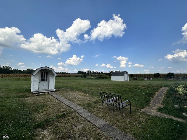 view of yard with a rural view, an outdoor structure, and a storage shed