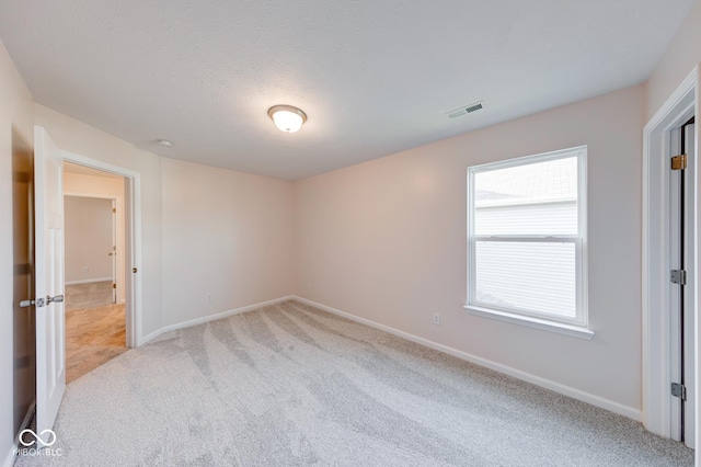 unfurnished bedroom featuring light carpet, visible vents, and baseboards