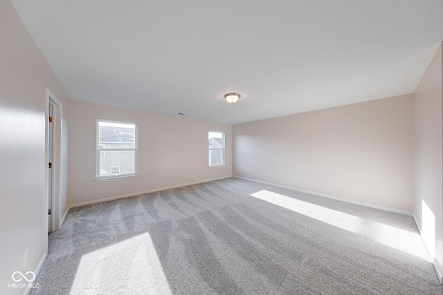 empty room with light colored carpet and baseboards