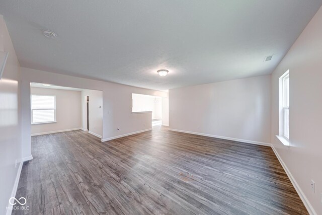 spare room with visible vents, baseboards, and wood finished floors