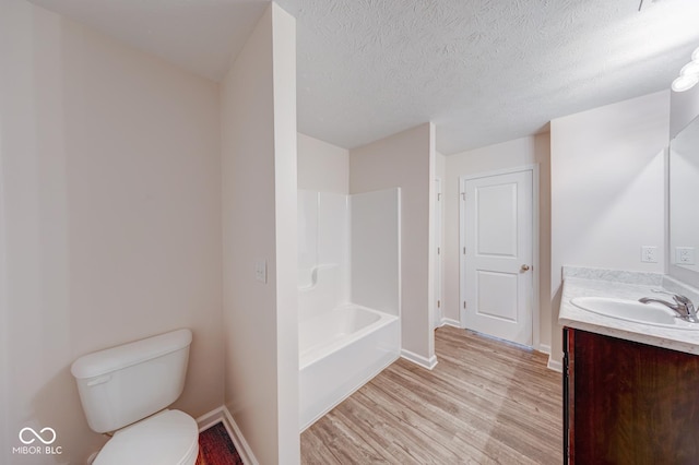 full bathroom with wood finished floors, baseboards, vanity, and toilet