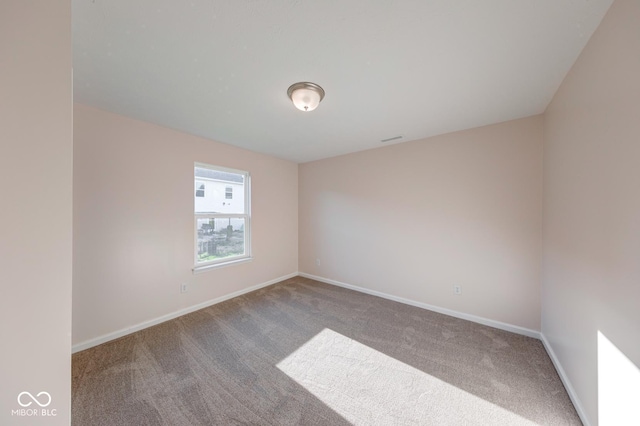unfurnished room with visible vents, carpet flooring, and baseboards