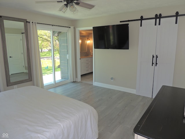 282 W Santee Dr, Greensburg, IN 47240 - bedroom featuring light wood-type flooring, a barn door, multiple windows, and access to outside