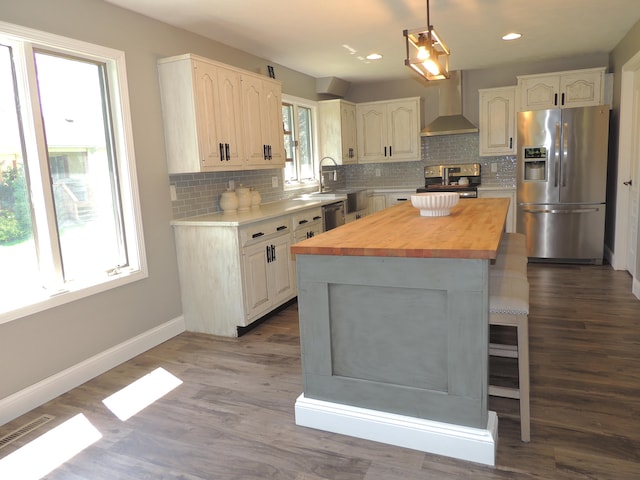 282 W Santee Dr, Greensburg, IN 47240 - kitchen featuring appliances with stainless steel finishes, wall chimney range hood, wood counters, tasteful backsplash, and a kitchen island