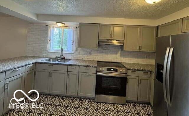 7833 Broadview Dr, Indianapolis, IN 46227 - kitchen featuring gray cabinetry, a textured ceiling, appliances with stainless steel finishes, and under cabinet range hood