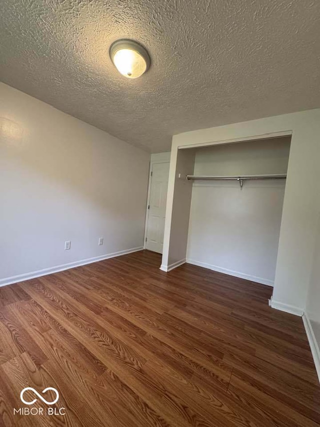 7833 Broadview Dr, Indianapolis, IN 46227 - unfurnished bedroom featuring wood finished floors, a textured ceiling, and a closet