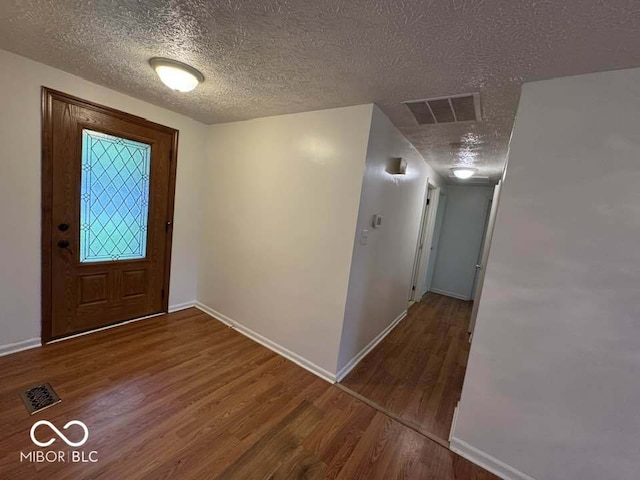 7833 Broadview Dr, Indianapolis, IN 46227 - foyer entrance featuring a textured ceiling, wood finished floors, visible vents, and baseboards
