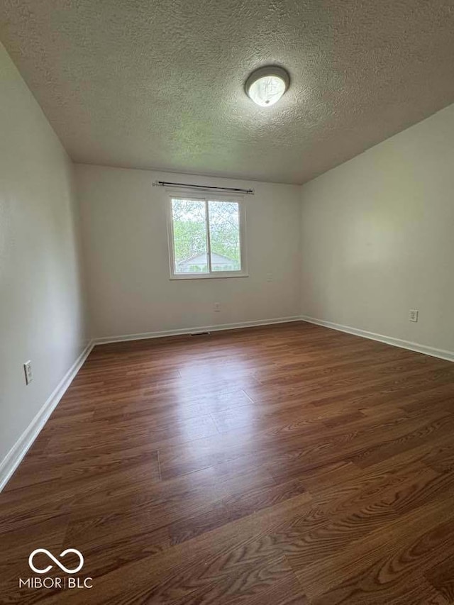 7833 Broadview Dr, Indianapolis, IN 46227 - spare room with baseboards, dark wood-style flooring, and a textured ceiling
