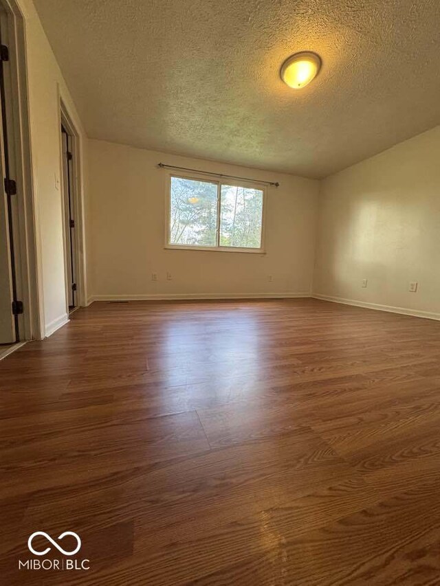 7833 Broadview Dr, Indianapolis, IN 46227 - spare room with baseboards, a textured ceiling, and dark wood-style floors