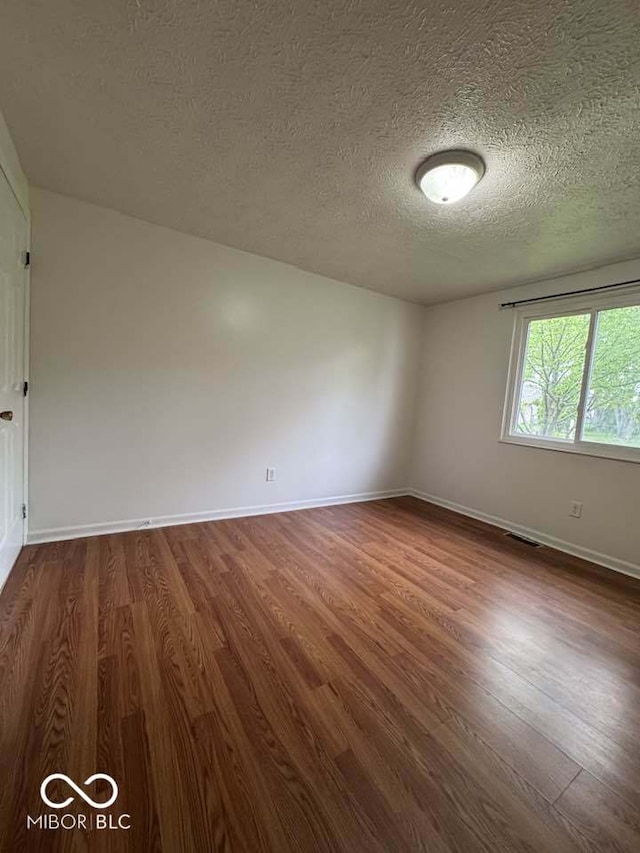 7833 Broadview Dr, Indianapolis, IN 46227 - unfurnished room with a textured ceiling, baseboards, and dark wood-style flooring