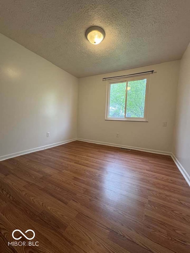 7833 Broadview Dr, Indianapolis, IN 46227 - spare room featuring baseboards, a textured ceiling, and dark wood-style floors