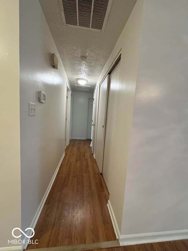 7833 Broadview Dr, Indianapolis, IN 46227 - hall with baseboards, wood finished floors, a textured ceiling, and visible vents
