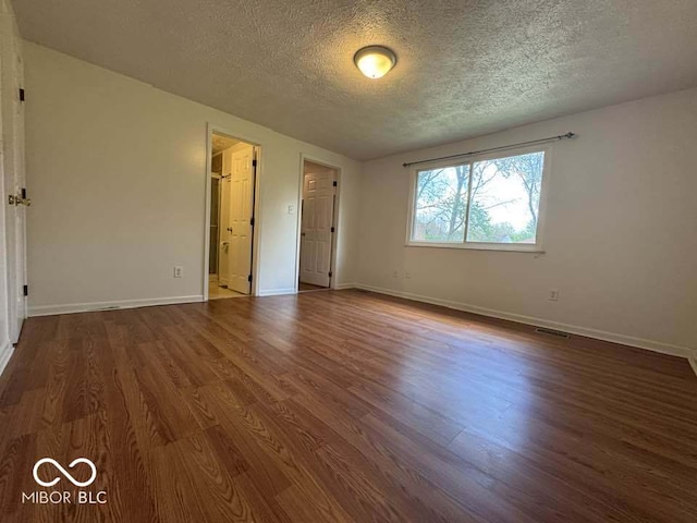 7833 Broadview Dr, Indianapolis, IN 46227 - unfurnished bedroom featuring dark wood finished floors, a textured ceiling, baseboards, and visible vents
