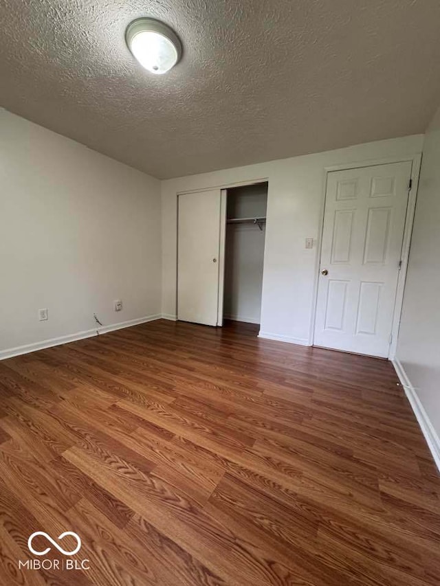 7833 Broadview Dr, Indianapolis, IN 46227 - unfurnished bedroom with a closet, wood finished floors, a textured ceiling, and baseboards