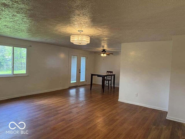 7833 Broadview Dr, Indianapolis, IN 46227 - unfurnished room with dark wood finished floors, baseboards, a textured ceiling, and ceiling fan with notable chandelier