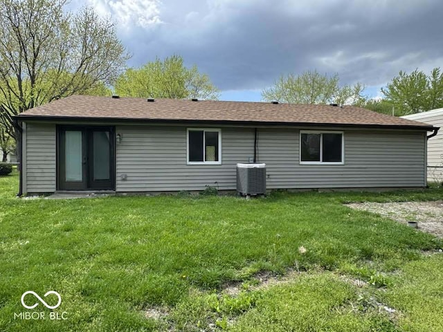 7833 Broadview Dr, Indianapolis, IN 46227 - back of property with french doors, central air condition unit, a lawn, and roof with shingles