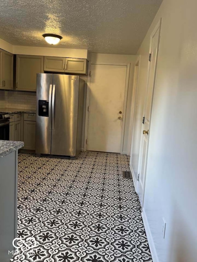 7833 Broadview Dr, Indianapolis, IN 46227 - kitchen featuring a textured ceiling, tasteful backsplash, stainless steel fridge with ice dispenser, gray cabinets, and black range with gas stovetop