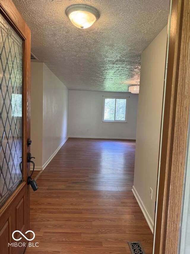 7833 Broadview Dr, Indianapolis, IN 46227 - entrance foyer featuring wood finished floors, a textured ceiling, baseboards, and visible vents