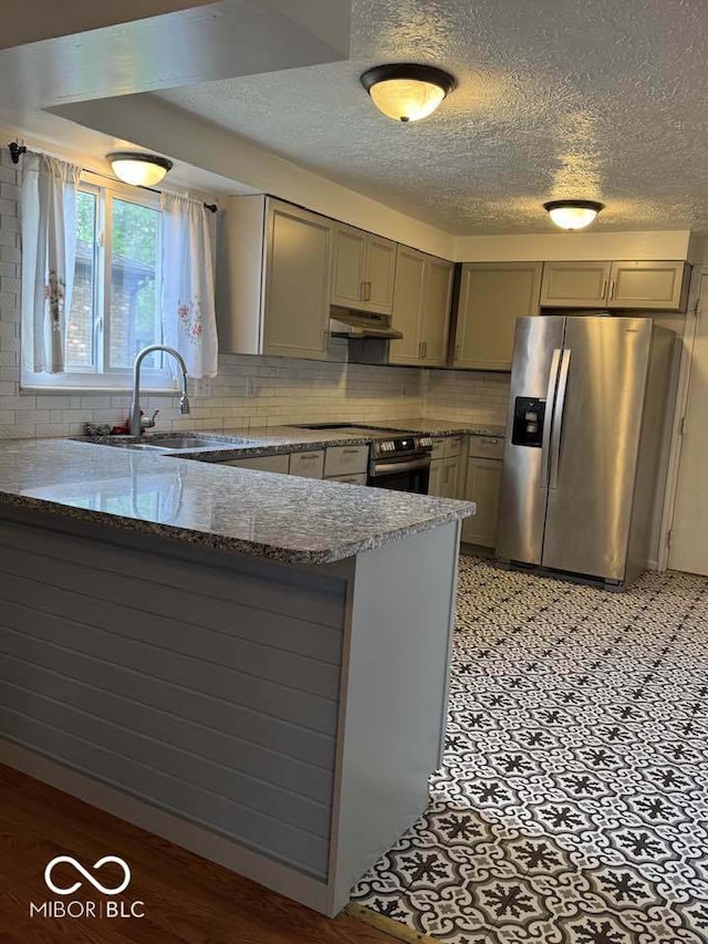 7833 Broadview Dr, Indianapolis, IN 46227 - kitchen with stainless steel fridge, gray cabinets, gas range, a peninsula, and under cabinet range hood
