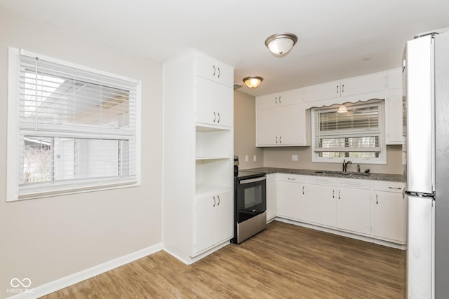 9535 E Michigan St, Indianapolis, IN 46229 - kitchen with white cabinetry, a sink, dark countertops, stainless steel appliances, and wood finished floors