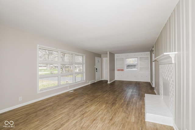 9535 E Michigan St, Indianapolis, IN 46229 - unfurnished living room with visible vents, wood finished floors, and baseboards