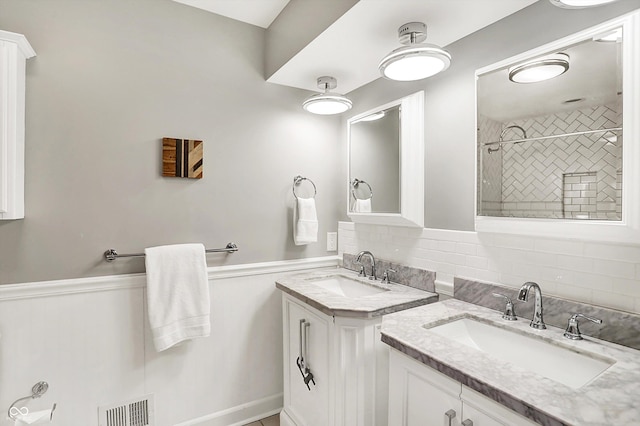 11626 Forest Dr, Carmel, IN 46033 - full bathroom featuring two vanities, backsplash, wainscoting, and tiled shower