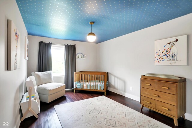 11626 Forest Dr, Carmel, IN 46033 - bedroom with hardwood / wood-style floors, a nursery area, and baseboards