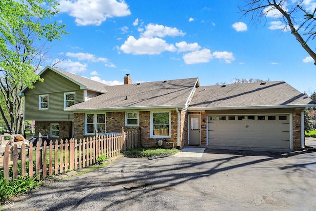 11626 Forest Dr, Carmel, IN 46033 - split level home with brick siding, fence, a shingled roof, a chimney, and driveway