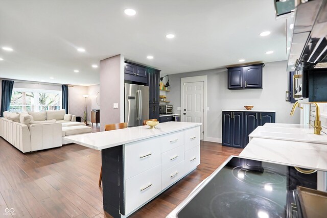 11626 Forest Dr, Carmel, IN 46033 - kitchen featuring stainless steel refrigerator, light countertops, dark wood-type flooring, a kitchen island, and recessed lighting