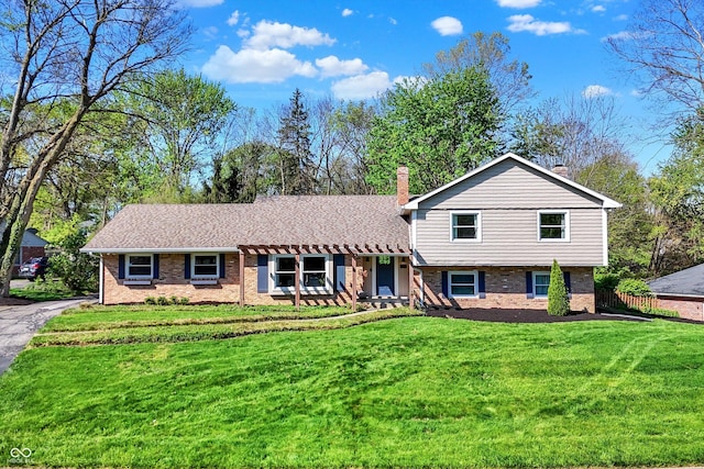 11626 Forest Dr, Carmel, IN 46033 - tri-level home featuring a front yard, brick siding, and a chimney