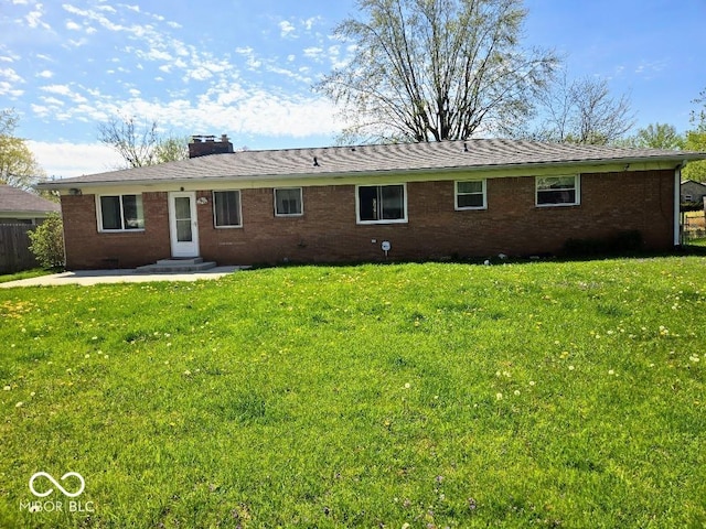 8230 E 11th St, Indianapolis, IN 46219 - back of house with brick siding, a yard, and a patio