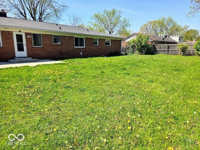 8230 E 11th St, Indianapolis, IN 46219 - back of property with fence, a lawn, and brick siding