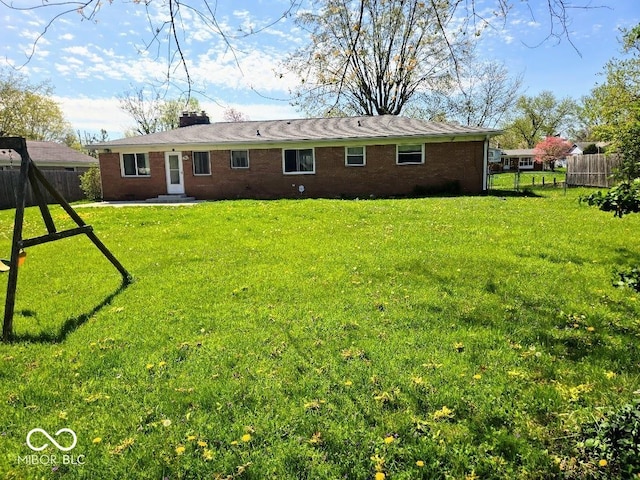 8230 E 11th St, Indianapolis, IN 46219 - back of house featuring brick siding, fence, and a lawn