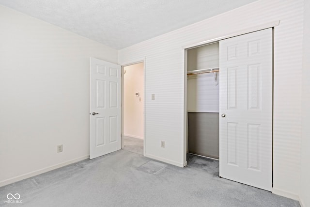unfurnished bedroom with carpet floors, baseboards, and a closet