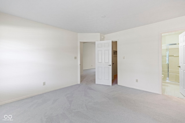 spare room featuring baseboards and light carpet