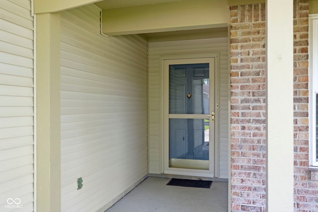 view of exterior entry with brick siding
