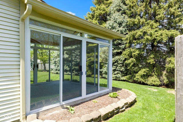 view of property exterior featuring a lawn and a sunroom