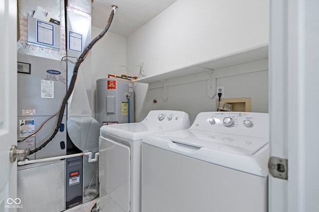 clothes washing area with water heater, laundry area, and washing machine and dryer