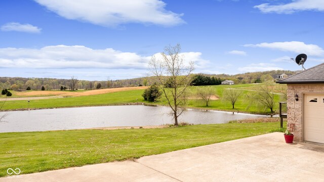 view of yard featuring a water view and a garage