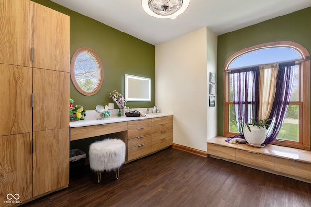 bathroom featuring baseboards, wood finished floors, and vanity