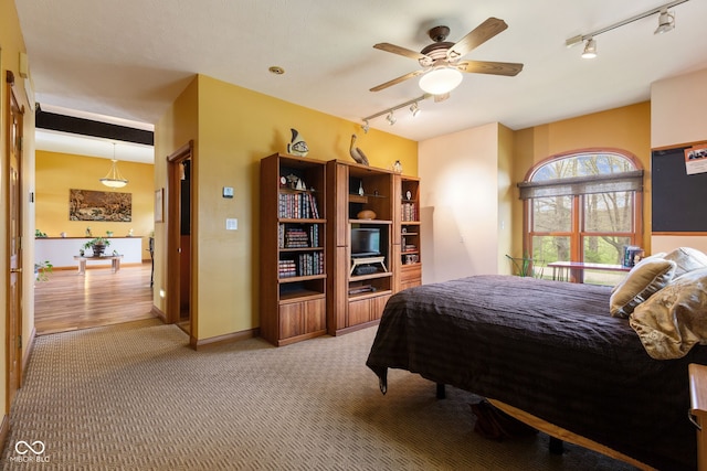 carpeted bedroom featuring a ceiling fan and rail lighting