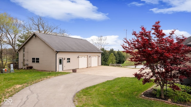 view of home's exterior featuring a detached garage, an outbuilding, roof with shingles, and a lawn