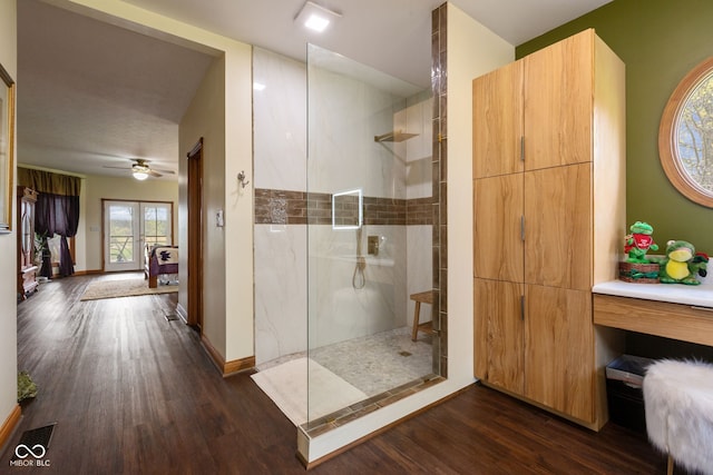 bathroom featuring wood finished floors, a ceiling fan, baseboards, and a walk in shower