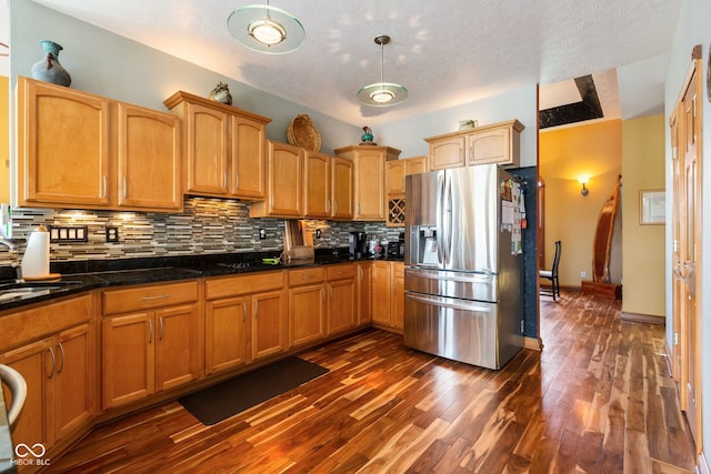 kitchen featuring dark wood-style floors, stainless steel fridge with ice dispenser, a sink, decorative light fixtures, and decorative backsplash