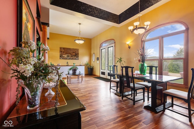 dining area featuring wood finished floors, baseboards, and a notable chandelier